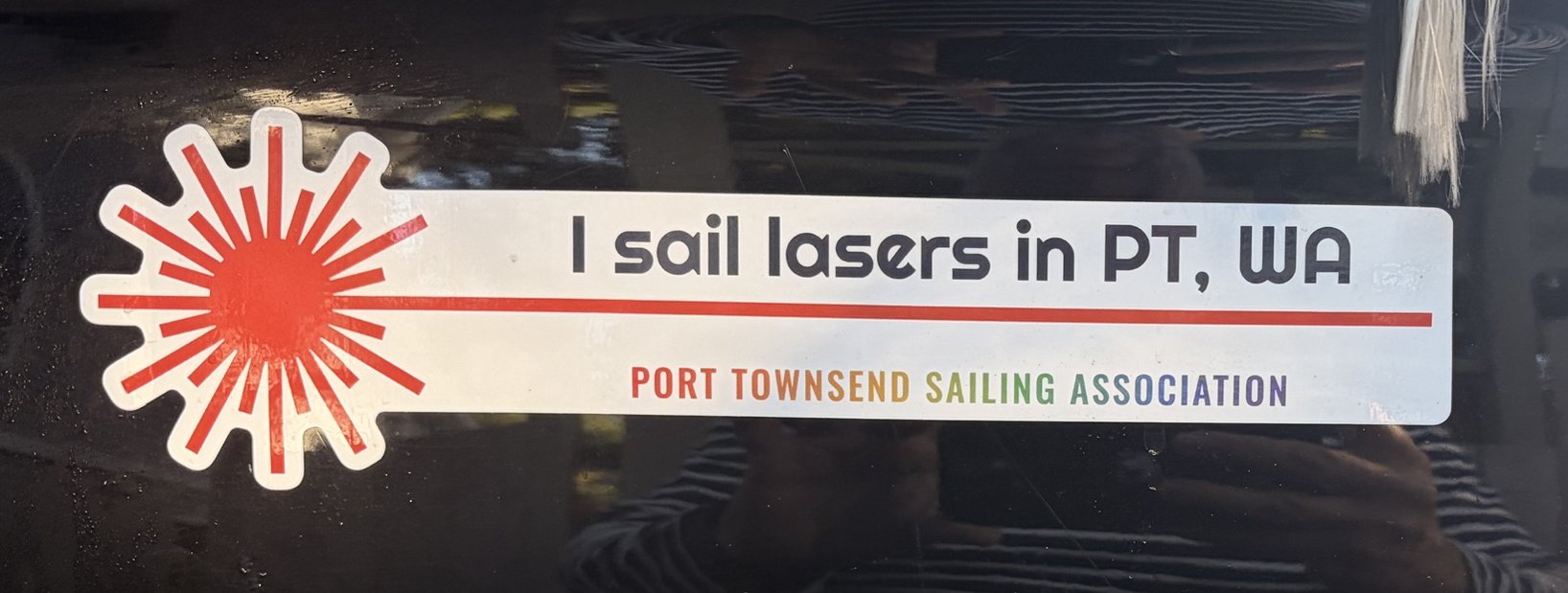 Bumper sticker on a black truck reading 'I sail lasers in PT, WA — Port Townsend Sailing Association'