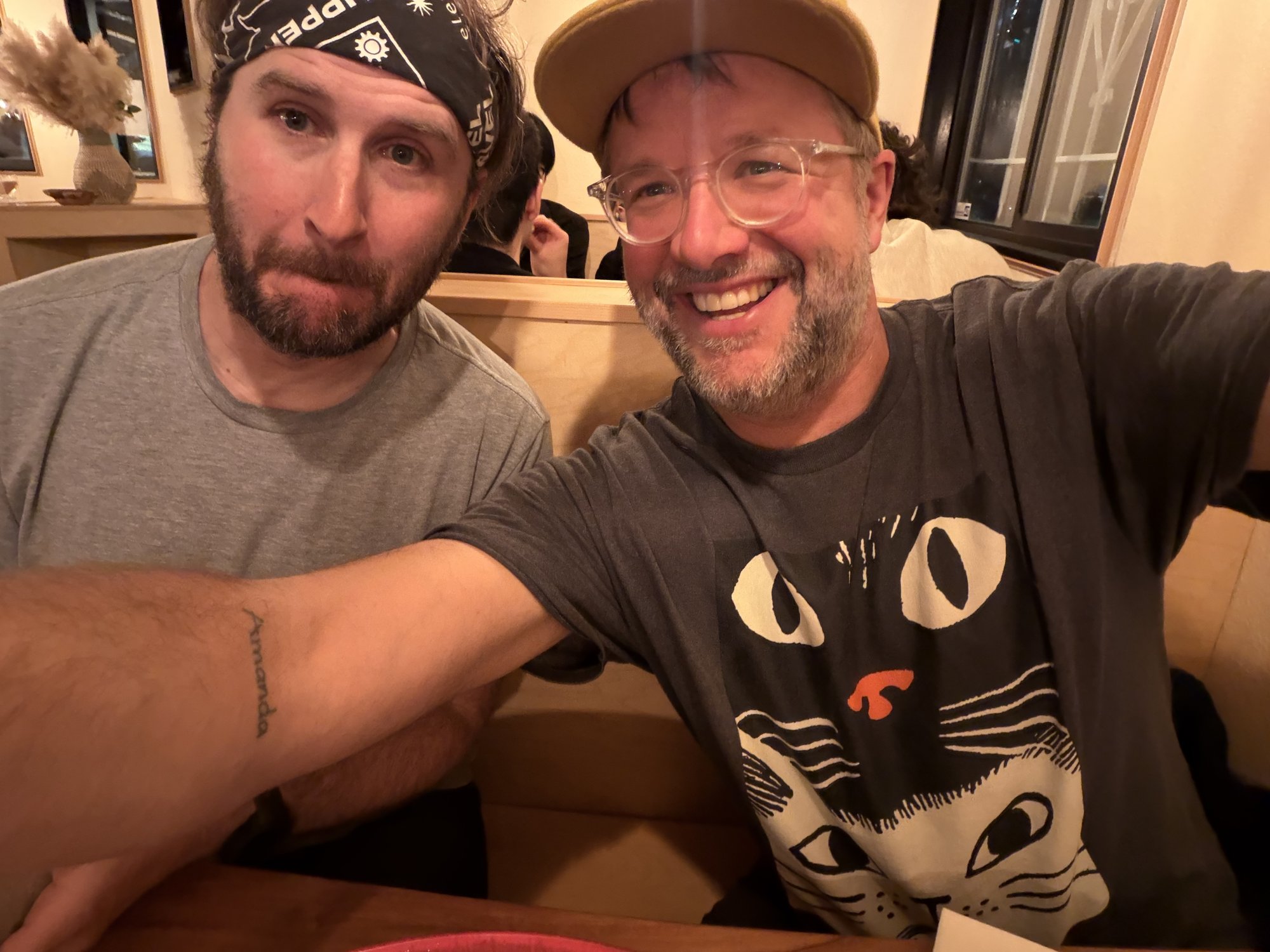 Two sailors grinning in a restaurant booth